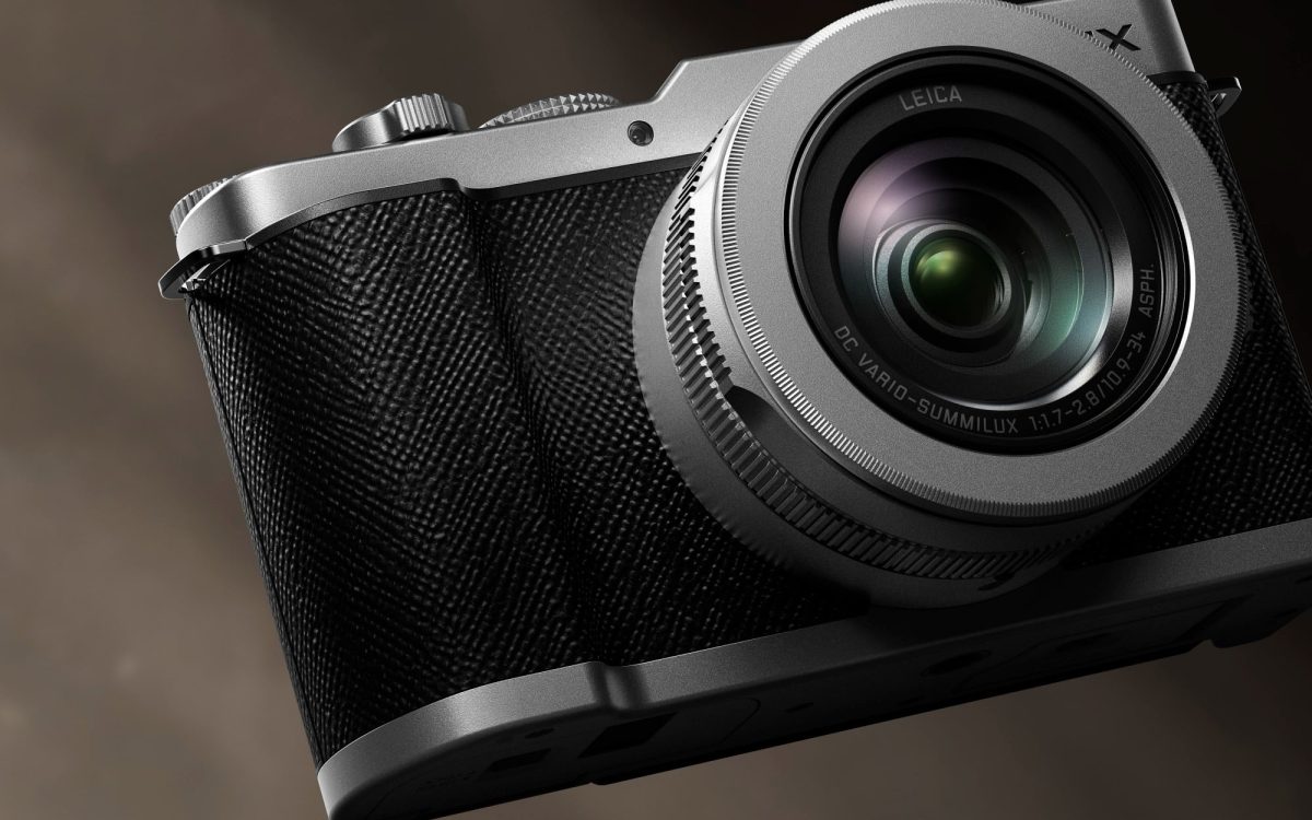 نمای نزدیک از لنز Leica روی دوربین Lumix با بدنه فلزی و روکش بافتدار.